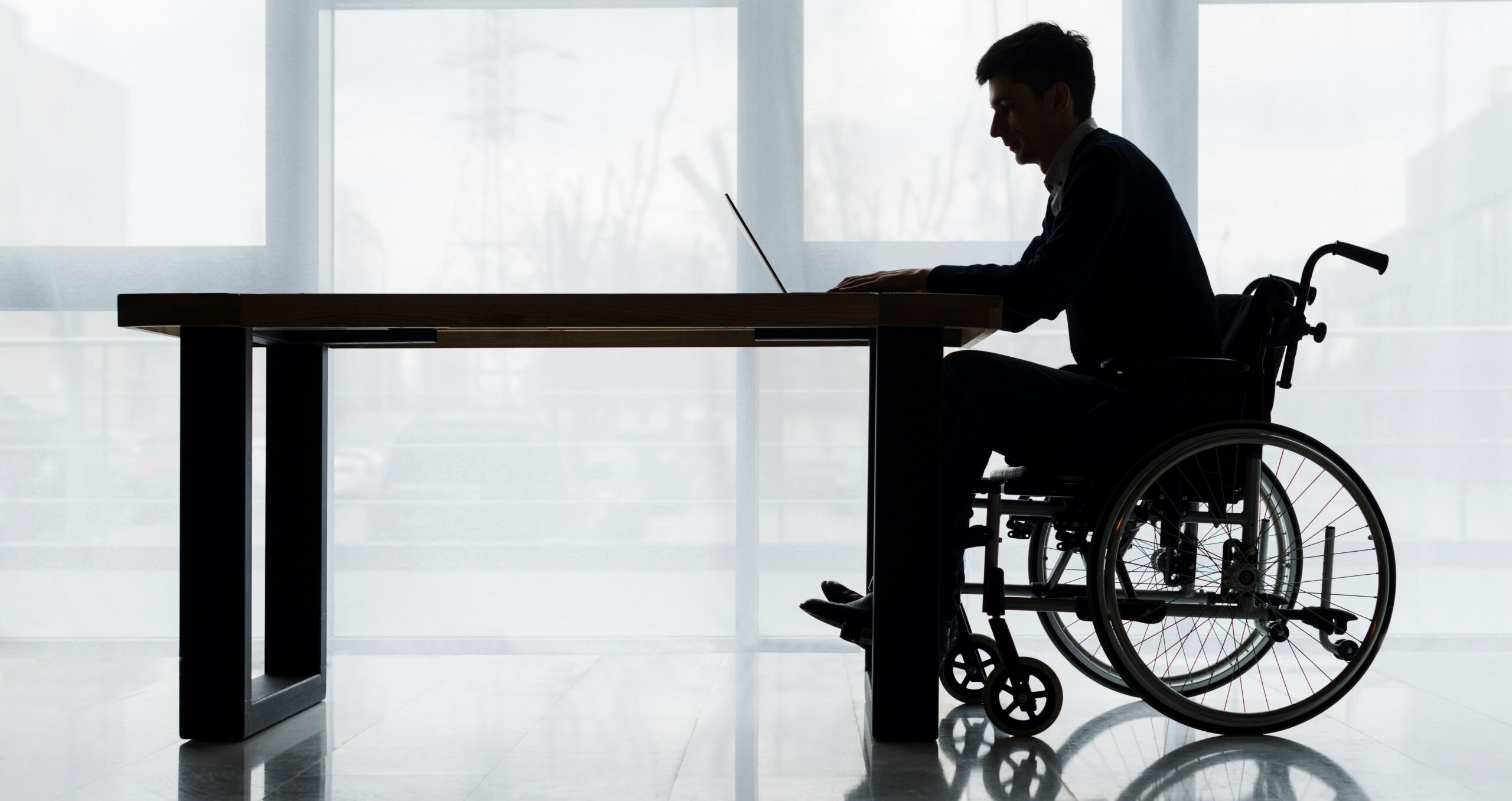 silhouette-businessman-sitting-wheelchair-using-laptop-table-front-window – Copy silhouette-businessman-sitting-wheelchair-using-laptop-table-front-window - Copy